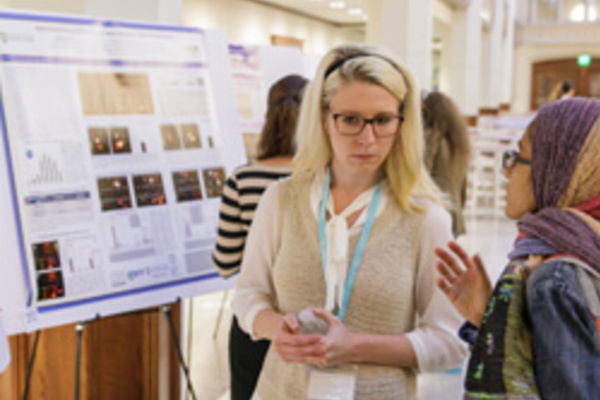 Jamie Luther talks with another student about her research.