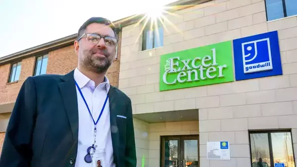 Rizan Hajji Mohamed stands in front of The Excel Center building in Indianapolis