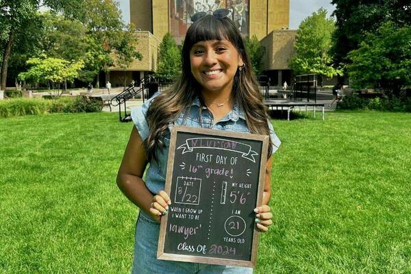 Lulu Romero '24 stands in front of the World of Life mural on her first day of class senior year.