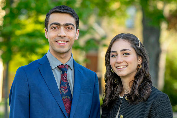 2024 Salutatorian Shaker Erbini and Valedictorian Isabela Tasende pose for a photo together outside the Main Building on campus (photo by Barbara Johnston/University of Notre Dame)