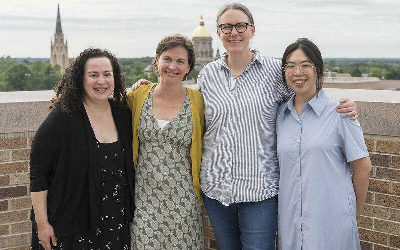 Athena in Action organizers Elizabeth Harman, Elisabeth Camp, Meghan Sullivan, and Sara Chan stand together on a balcony with the Dome and Basilica in the background.