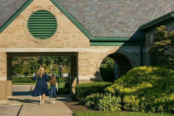 Photo of mom and child walking on campus