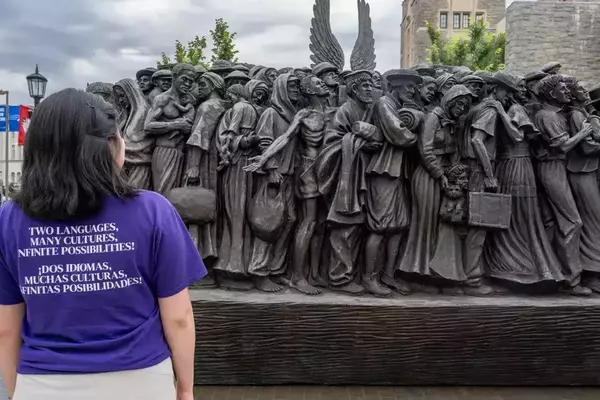 Elsy Pineda gazes at the Angels Unawares sculpture, a bronze sculpture of migrants and refugees from various lands crowded on a 20-foot boat at the Catholic University of America in Washington, D.C.